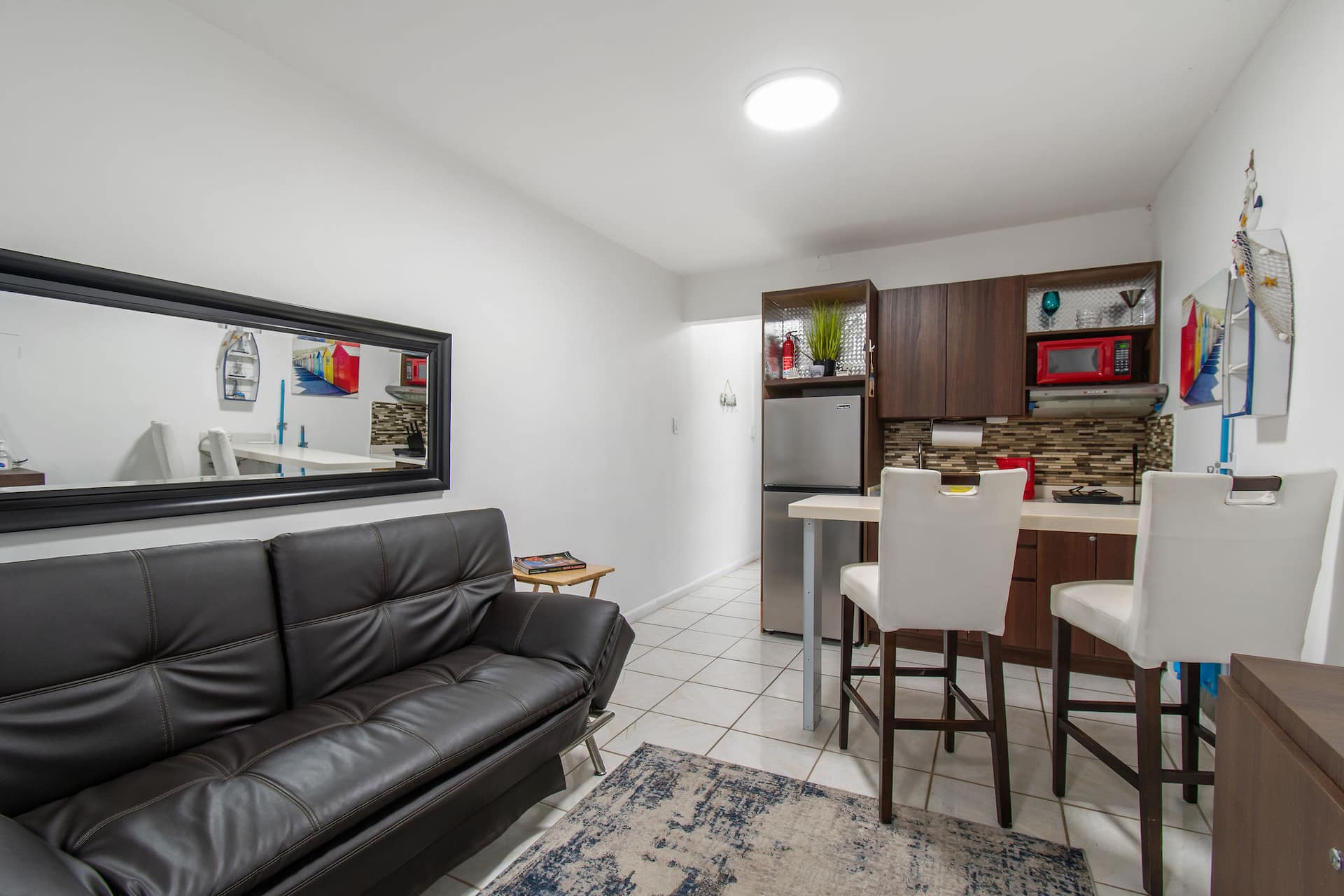 Marlin living area with a futon, a wide mirror and the kitchenette